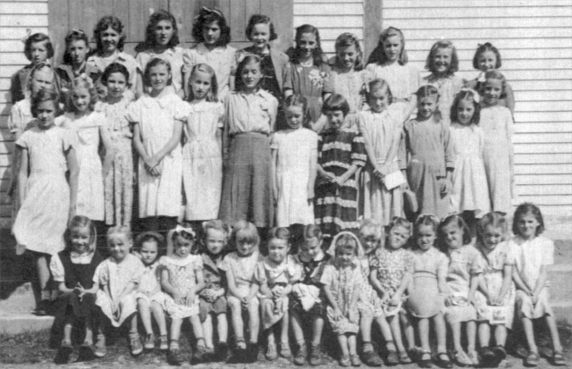 513: Group of 39 young ladies. (circa 1950) [courtesy of Lorna Richardson] ** also see 511 &amp;amp; 512 **  Standing in back row (top step) left-to-right, Imelda Ryan, Annie Norman, Marg Norman,  Marie Ryan, Angela Ryan, Gwen Carroll, Marie Counsel, Teresa Whelan, Beth Lambe, Kathleen Barry,  Teresa Norman; standing in second row from back (second step), Madonna McCarthy, Babe Ennis,  Mary Finn, Noreen Ryan, Mary Ennis, Madonna Whelan, Kathleen Lambe, unidentified,  Gert Ryan, Teresa Kerrivan, Lorraine Kerrivan, Anne Counsel; standing on first step, Mary Reddy;  sitting on first step left-to-right, ? Ennis, unidentified, Sheila Ryan (wearing bonnet),  unidentified (with white bow), unidentified, ? Ennis, Irene Webber, unidentified (dark dress),  unidentified (wearing white head covering), unidentified, Hilda Whelan, unidentified,  Rita Whelan, unidentified, Bernardine Whelan. ** more details below **  - Kathleen Barry (of Thomas Barry &amp;amp; Anne Dollimont)  - Gwen Carroll (of Michael Carroll &amp;amp; Josephine Barry)  - Anne Counsel (of Michael Counsel &amp;amp; Mary Anne Barry)  - Marie Counsel (of Michael Counsel &amp;amp; Mary Anne Barry)  - Babe Ennis (of Vincent Ennis &amp;amp; Mary Carroll)  - Mary Ennis (of Vincent Ennis &amp;amp; Mary Carroll)  - Mary Finn (of Patrick Finn &amp;amp; Helena Hayward)  - Lorraine Kerrivan (of James Kerrivan &amp;amp; Josephine Norman)  - Teresa Kerrivan (of Peter Kerrivan &amp;amp; Cecilia Cheeseman)  - Beth Lambe (of James Lambe &amp;amp; Catherine Rodgers)  - Kathleen Lambe (of James Lambe &amp;amp; Catherine Rodgers)  - Madonna McCarthy (of James McCarthy &amp;amp; Mary Ellen Barry)  - Annie Norman (of John Norman &amp;amp; Mary Farget)  - Marg Norman (of Charles Norman &amp;amp; Elizabeth Anne Barry)  - Teresa Norman (of Peter Norman &amp;amp; Margaret Norman)  - Mary Reddy (of Michael Reddy &amp;amp; Elizabeth Moore)  - Angela Ryan (of Michael Ryan &amp;amp; Petronella Whelan)  - Gert Ryan (of Jeremiah Ryan &amp;amp; Josephine Lambe)  - Imelda Ryan (of Jeremiah Ryan &amp;amp; Josephine Lambe)  - Marie Ryan (of Joseph Ryan &amp;amp; Ursula Barry)  - Noreen Ryan (of Albert Ryan &amp;amp; Catherine Nolan)  - Sheila Ryan (of Albert Ryan &amp;amp; Catherine Nolan)  - Irene Webber (of William Webber &amp;amp; Anne Counsel)  - Bernardine Whelan (of Leo Whelan &amp;amp; Elizabeth Bishop)  - Hilda Whelan (of Leo Whelan &amp;amp; Elizabeth Bishop)  - Madonna Whelan (of Leo Whelan &amp;amp; Elizabeth Bishop)  - Rita Whelan (of Leo Whelan &amp;amp; Elizabeth Bishop)  - Teresa Whelan (of Leo Whelan &amp;amp; Elizabeth Bishop)